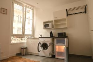 a kitchen with a washing machine and a microwave at Orléans in Paris