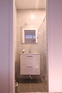 a bathroom with a white sink and a mirror at Orléans in Paris