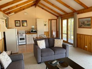 a living room with a couch and a kitchen at Warby Cottage in Wangaratta