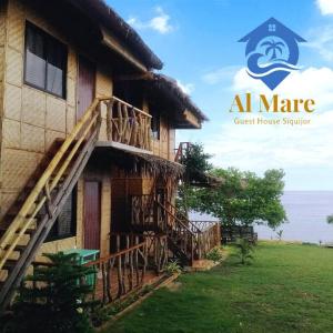 a building with a staircase next to the ocean at Almare Guest House Siquijor in San Juan