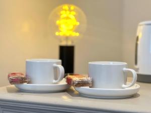due tazze di caffè sedute sopra un bancone di Webbys Windrush Walk a Bourton on the Water