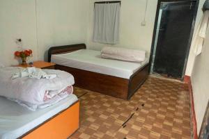 Habitación con 2 camas individuales y ventana. en Ayodhyapuri Community Homestay en Chitwan