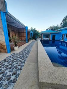 a house with a swimming pool next to a building at R&D Traveller's Inn in Anda