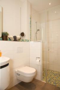 a white bathroom with a toilet and a shower at Ferienwohnung Teldec in Nortorf