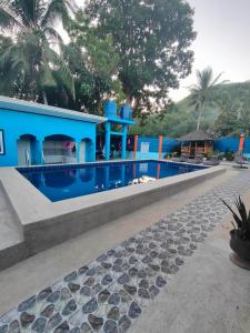 una casa azul con piscina frente a ella en R&D Traveller's Inn en Anda