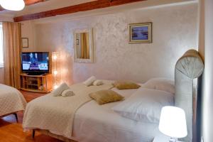 a bedroom with two white beds and a television at Apartment Baćo in Split