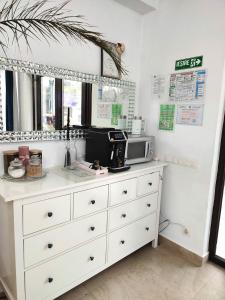 a kitchen with a white dresser with a microwave at Regal Guest House in Sighetu Marmaţiei