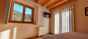 Schlafzimmer mit einem Bett und einem Fenster in der Unterkunft Antiga Rectoria, Aidí. in Aydí