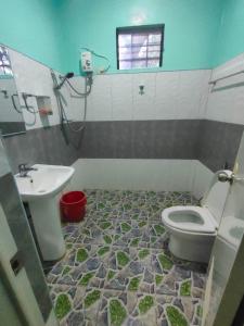 ein Bad mit einem WC und einem Waschbecken in der Unterkunft R&D Traveller's Inn in Anda