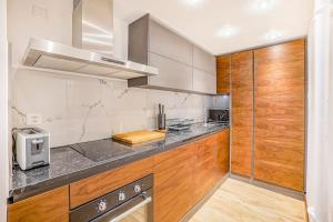 a kitchen with stainless steel appliances and wooden cabinets at Montreux exclusive and classy flat in Montreux