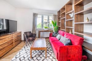 a living room with a red couch and a tv at Montreux exclusive and classy flat in Montreux