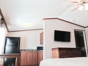 a bedroom with a bed and a tv on the wall at Oasis Lodge in Big Lake