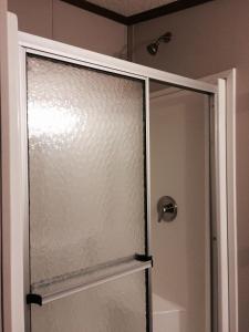a shower with a glass door in a bathroom at Oasis Lodge in Big Lake