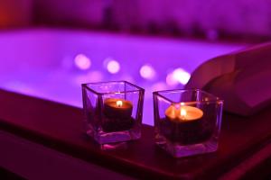 two votive candles sitting on a table next to a pool at Boscò Suites in Carini