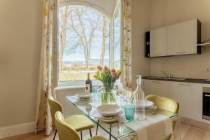 a dining room with a table with chairs and a window at Casa Valentina in Lucca +8 photos