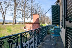 a balcony with chairs and a view of a park at Casa Valentina in Lucca