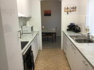 a kitchen with white cabinets and a sink at Camelot 18 in Forster