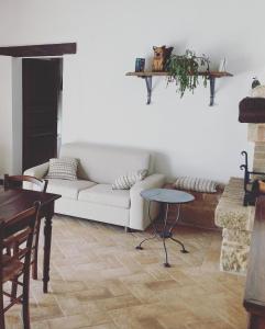 a living room with a white couch and a table at Agriturismo Santa Maria in Pienza