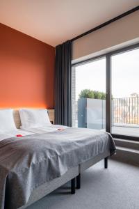 a bedroom with a bed and a large window at Citybox Antwerp in Antwerp