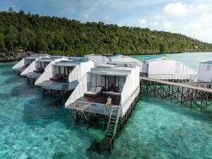 uma fila de alojamentos de turismo selvagem na água num cais em Arasatu Villas & Sanctuary em Maratua Atoll