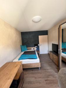 Schlafzimmer mit einem Bett und einem Holztisch in der Unterkunft Gasthof Seeklause in Pfedelbach