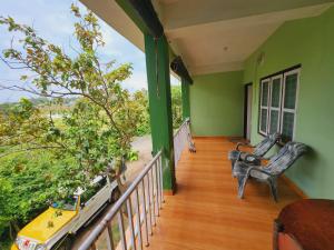 a balcony with two chairs on a house at Wildways Mudumalai Homestay in Masinagudi