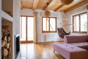 a living room with a couch and some windows at Amenity Hotel & Resort Lipno in Lipno nad Vltavou