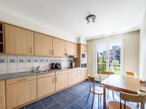 une cuisine avec des placards en bois, une table et une fenêtre dans l'établissement Forum Luxury Apartment Lake View, à Montreux