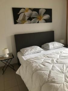 a bedroom with two white beds and a painting on the wall at Zeepark Mercator in Molenwijk