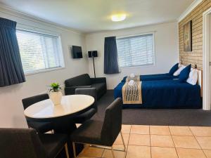 1 dormitorio con 1 cama, mesa y sillas en Leichhardt Motor Inn en Toowoomba