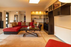 ein Wohnzimmer mit einem roten Sofa und einem Tisch in der Unterkunft Family House in Nea Makri in Nea Makri