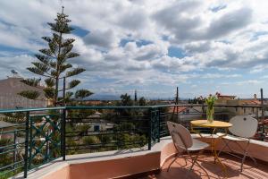 einen Balkon mit einem Weihnachtsbaum, einem Tisch und Stühlen in der Unterkunft Family House in Nea Makri in Nea Makri