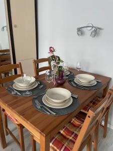 a wooden table with plates and wine glasses on it at Apartament Kamień Pomorski in Kamień Pomorski
