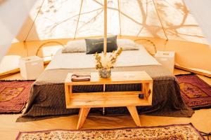 - une chambre avec un lit et une table en bois dans l'établissement The Spot Surfcamp, à Biscarrosse