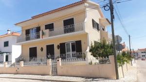 a white house with balconies on a street at Casa em Palmela - Setúbal in Palmela