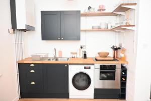 a kitchen with a washing machine and a sink at The Coach House - Bournemouth in Bournemouth