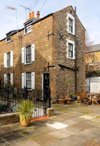 a brick building with a fence in front of it at Old Anchor Cottage, Broadstairs. in Broadstairs