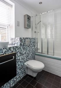 a bathroom with a toilet and a shower and a sink at Old Anchor Cottage, Broadstairs. in Broadstairs