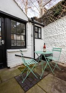 2 Stühle und ein Tisch vor einem Haus in der Unterkunft Old Anchor Cottage in Broadstairs - Winter special offers! in Broadstairs