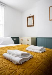 two towels sitting on top of a bed at Old Anchor Cottage, Broadstairs. in Broadstairs