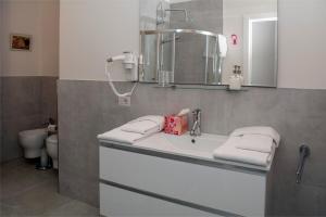 y baño con lavabo, espejo y aseo. en Torre San Bonifacio - Locazione Turistica, en San Bonifacio