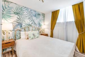 een slaapkamer met een wit bed en tropisch behang bij Urban style 3-bedroom apartment in Montreux