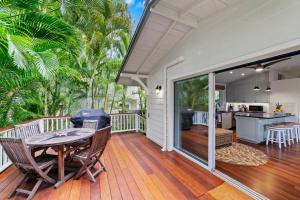 porche con mesa y sillas en la cubierta en Lanikai Ohana Hale, en Kailua