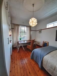 a bedroom with a bed and a desk and a window at Oppikoppi in Melville in Johannesburg