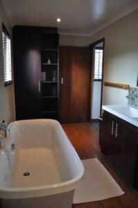 a bathroom with a white tub and a sink at Oppikoppi in Melville in Johannesburg