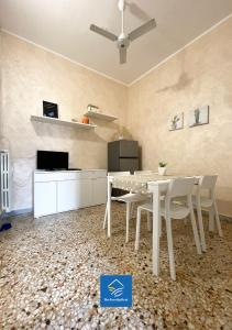 een eetkamer met een witte tafel en stoelen bij The Family Nest - Casa Eva in Manfredonia