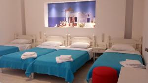 um quarto de hospital com três camas e uma janela em Margo Studios em Naxos Chora