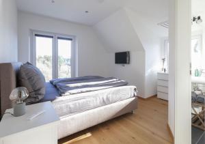 Residenz Kirchberg في آدناو: غرفة نوم بيضاء مع سرير وتلفزيون