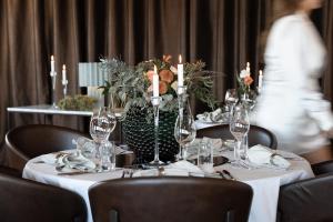 テルベリにあるHotell Villa Långbersの白いテーブルクロスとキャンドルと花のテーブル