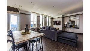 Pass the Keys Spacious Luxury Apartment in the Heart of London في لندن: غرفة معيشة مع أريكة وطاولة